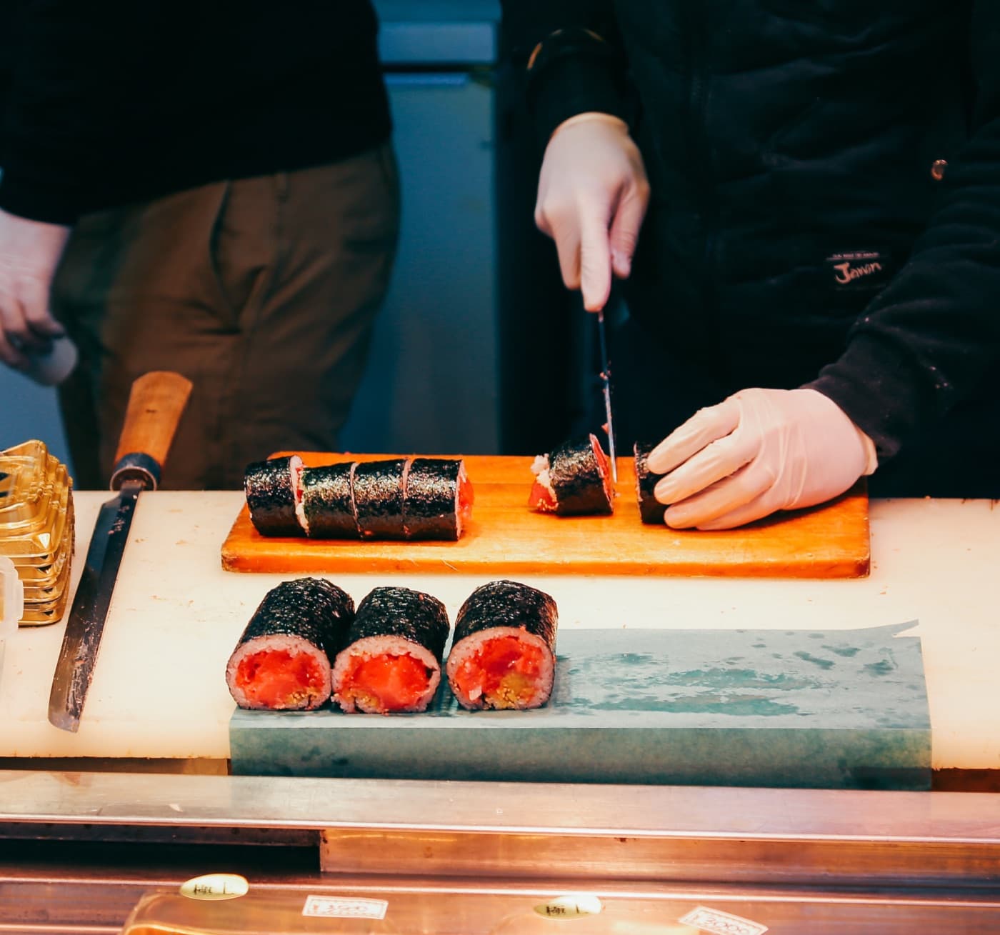 Uno chef taglia un rotolo di sushi al tonno